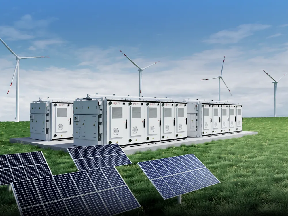 Grid-scale battery storage containers beside solar panels and wind turbines